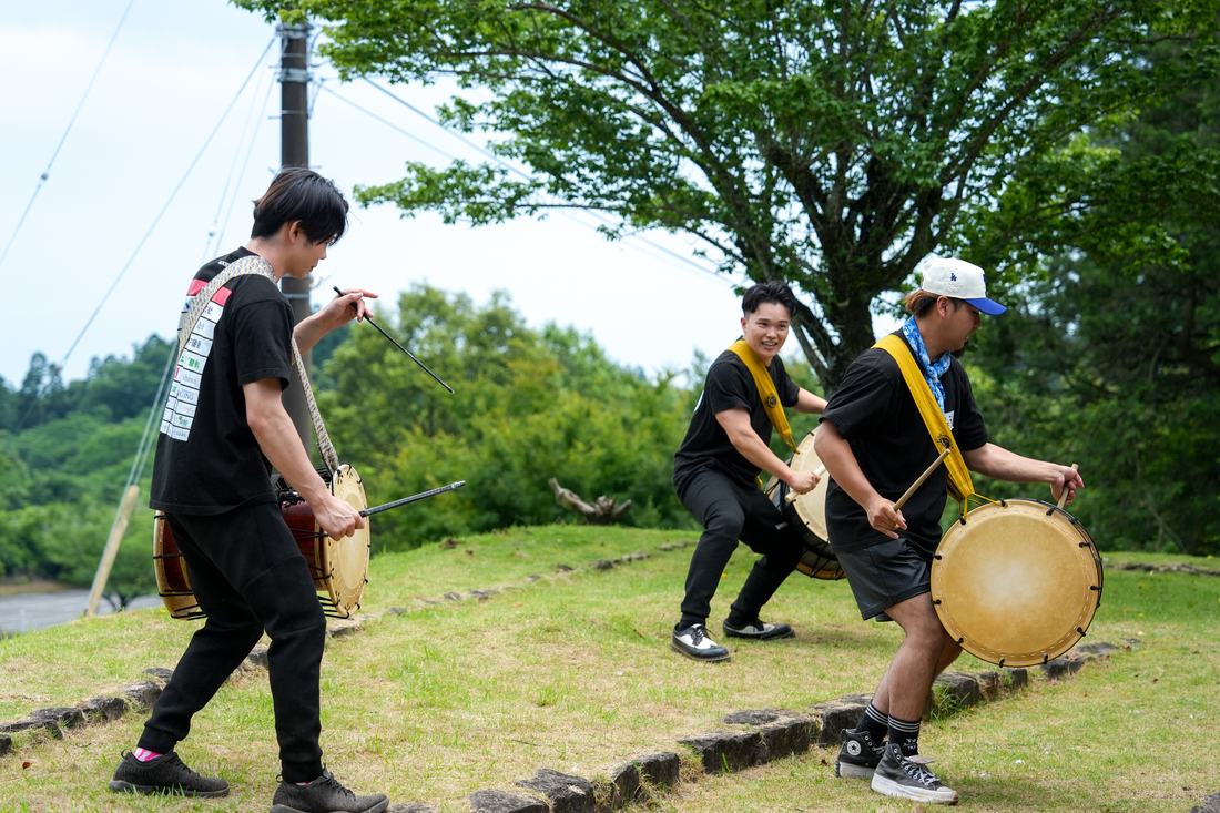屋外で担ぎ太鼓を打ちながら進むメンバー